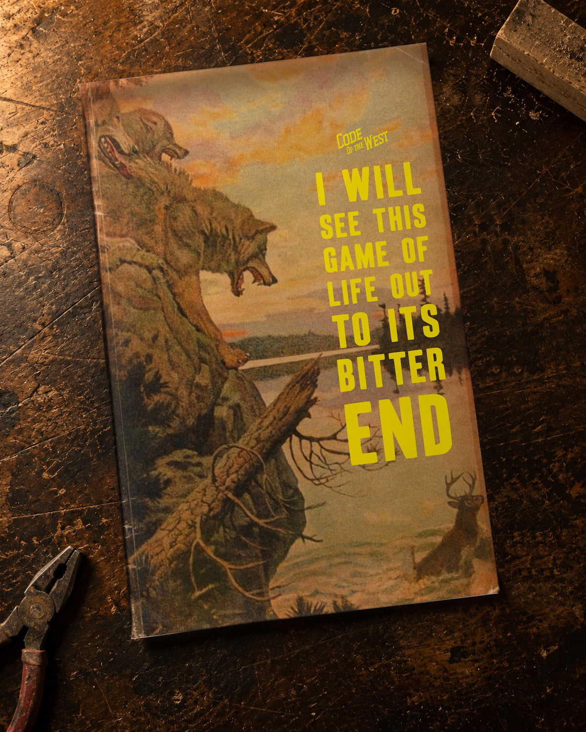 The Bitter End art print with yellow lettering and vintage wildlife artwork, shown on a wooden workbench
