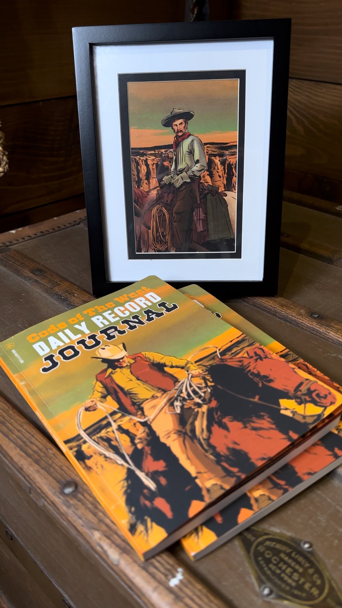 Daily Record Journal beside a framed example of its interior cowboy artwork