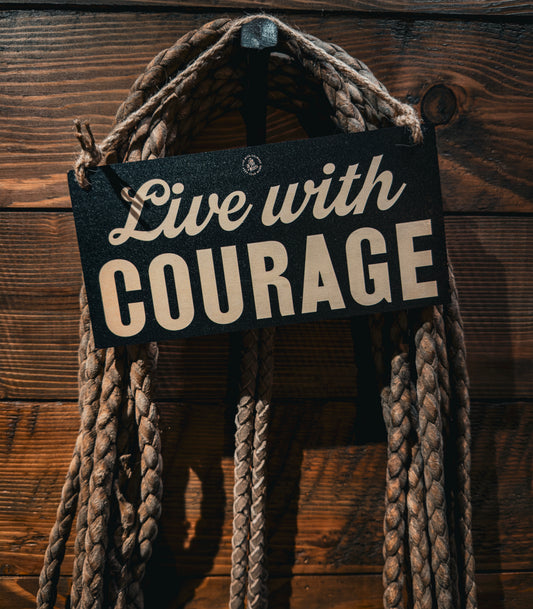 Live with Courage wood sign hanging against coiled rope and a wood wall