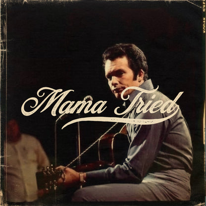 Man performing with a guitar and white Mama Tried lettering