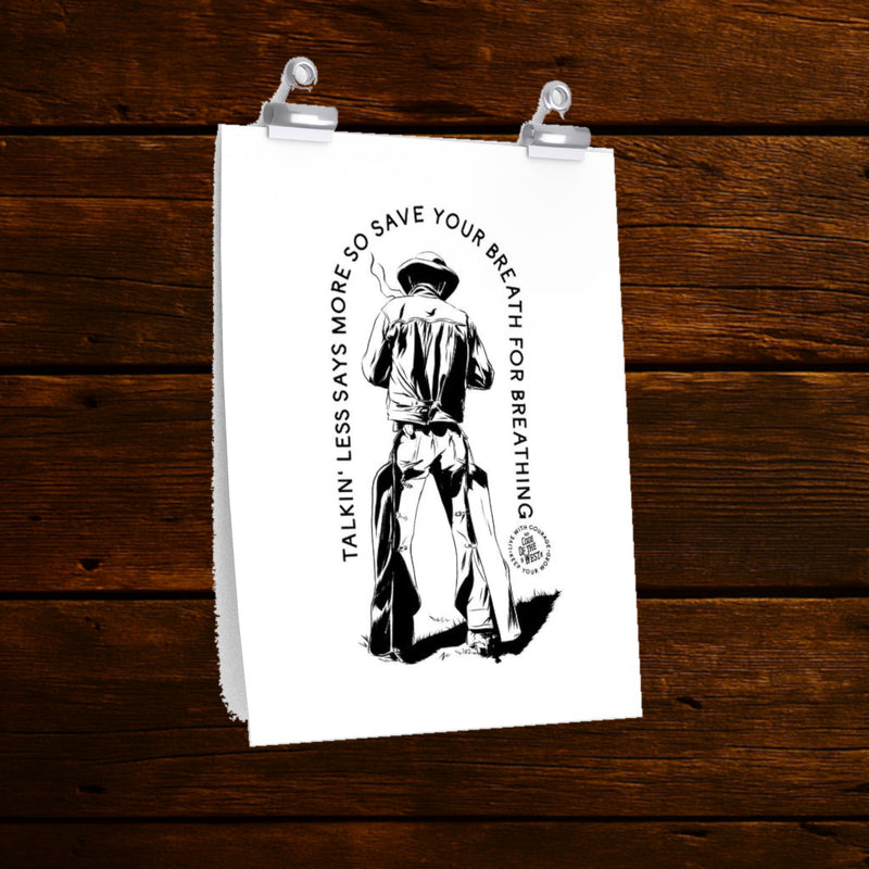 Talkin’ Less Says More art print with a cowboy seated backward on a chair and curved black lettering